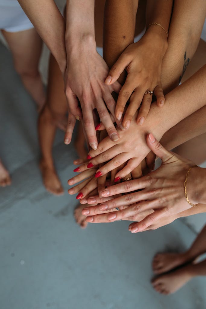 Close-up of diverse hands stacked together symbolizing unity and collaboration.